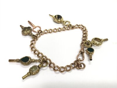 A 9ct rose gold charm bracelet with attached Watch keys. Approx weight 39.44 grams.