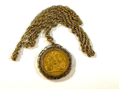 An Edward VII 1909 full sovereign with a 9ct gold coin mount and chain. 18.3g