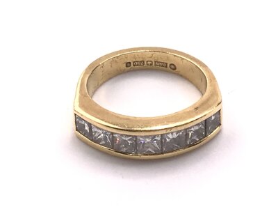 An 18ct gold ring set with seven square cut diamonds. RDRC to follow
7.37g and size N