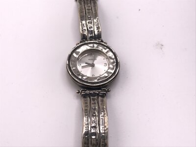 A silver case and strap watch. Not seen running.