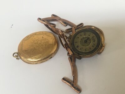A gold cased watch and linked sprung strap with a locket.