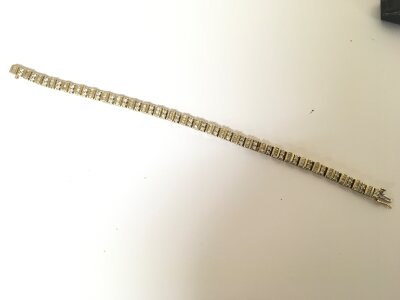 A 14carat gold tennis type bracelet set with alternating diamond set links of pairs of round brilliant cut diamonds and baguette diamonds. Weight 19g