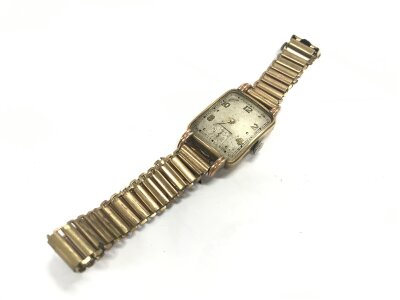 A 9 carat cased vintage watch with a rolled gold strap, 34g total weight.