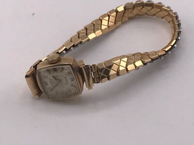A  small gold case  watch with gold plated strap.