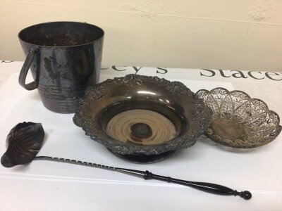 A white metal toddy ladle with turned ebony handle a white metal filigree dish a wine coaster and an ice bucket.