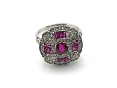 Platinum art deco style circular ring set with rubies and diamonds. Central Ruby 0.65ct approximately with 0.47ct diamonds and 0.38ct remaining rubies approximately. Size N