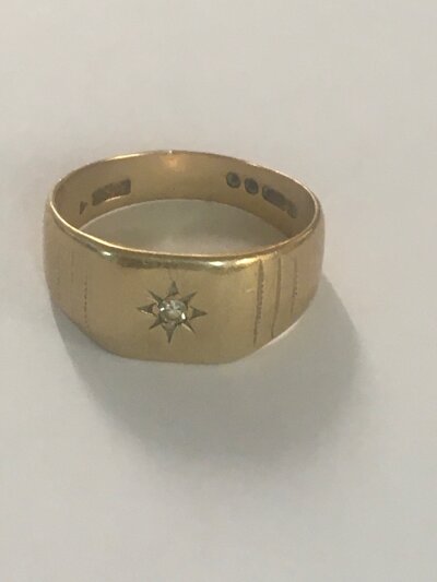 A 9ct gold ring inset with a small diamond chip 4.5 grams