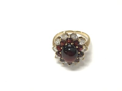 A 9ct gold cabochon garnet and white stone set ring.
Size N and 4.65g