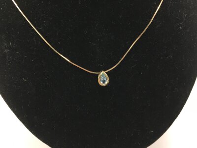A 9ct modern design yellow gold necklace set with aquamarine colour stone.
2.10g