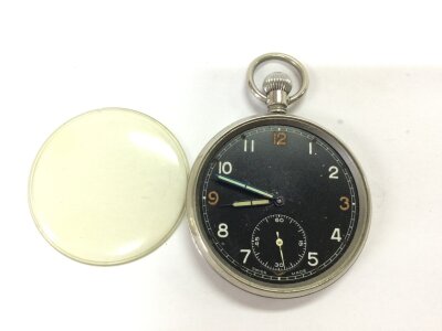 A military button wind pocket watch. Winds and seen running. Approximately 50mm case.