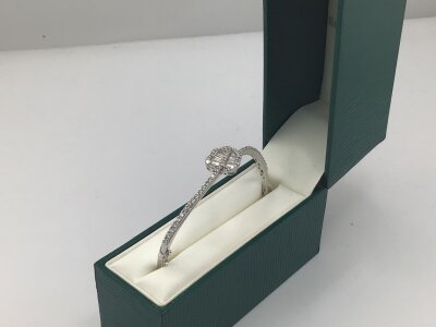 A quality 18carat white gold bangle of modern design set with baguette diamonds and brilliant cut round diamonds extending to half the bangle.