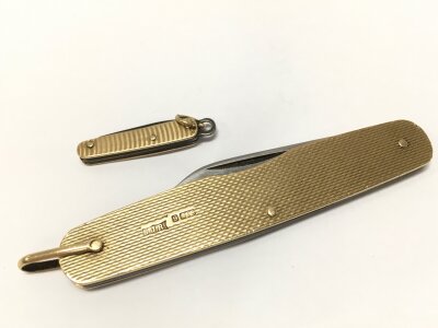 A 9ct gold penknife and a miniature knife. 32g total weight.