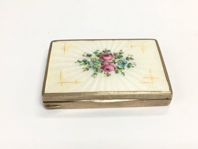 A vintage Austrian white metal compact with enamel floral spray decoration.