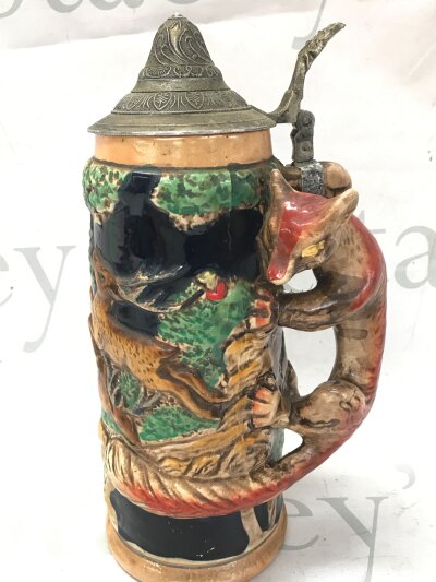 A vintage pottery beer stein with fox handle and music box inside, 25cm tall