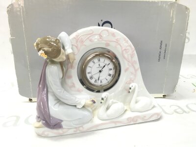A boxed Lladro porcelain Swan Clock (item #01005777) titled "Reloj Cisnes Mec. Cuarzo".  seen working. 19cm tall 25cm wide