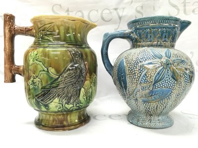Two art pottery jugs, one hawk design and other floral .24cm tall