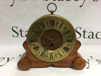 An antique brass mantle clock with a detachable wooden stand.- NO RESERVE