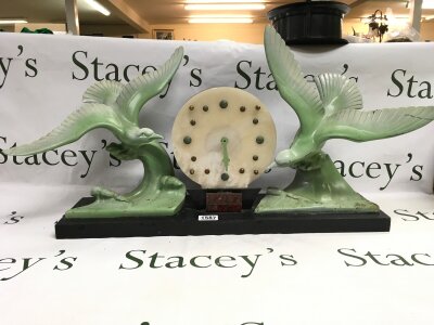 An art deco black marble mantle clock with sculptured bird garnitures.