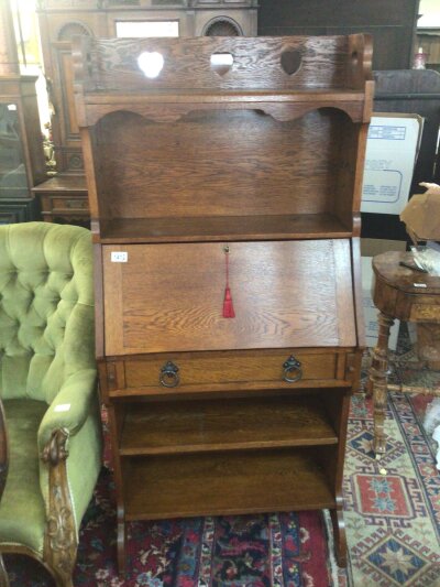 An oak Arts and Crafts bureau with a raised back fall front and open shelfs. Height 152cm