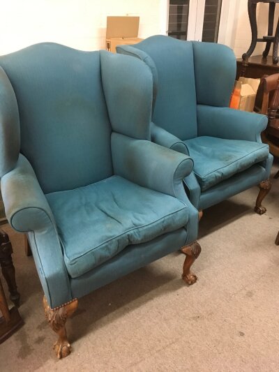 A pair of wing back open armchairs in a teal coloured upholstery.