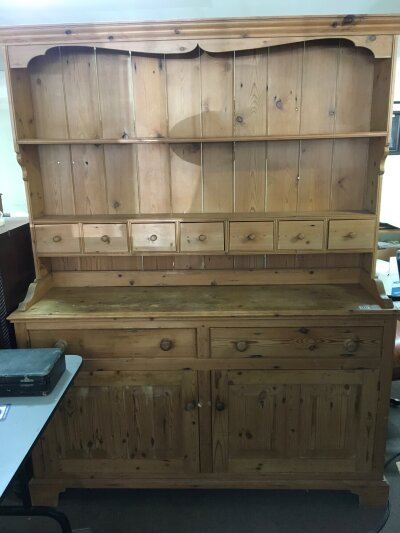 A pine dresser with a raised back with spice drawers and open shelves above drawers and cupboards 156cm wide