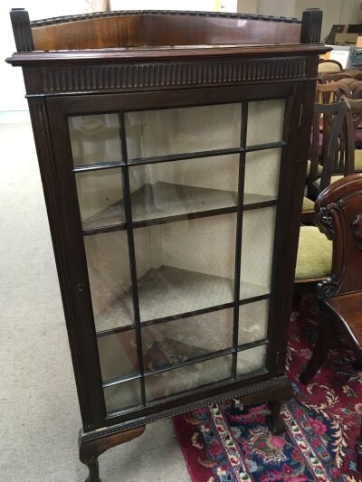 A Mahogany corner display cabinet with a single glazed door on ball and claw feet