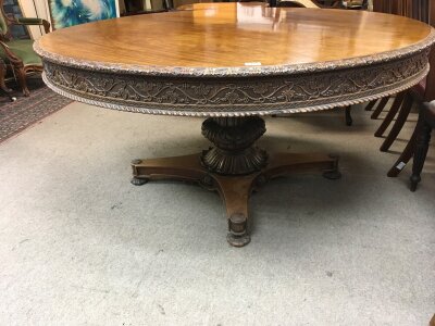 A Rare Padouck wood Late Regency Period Dining table possibly British Colonial the large circular top with a carved frieze hinged on an elaborate carved column top diameter 151cm