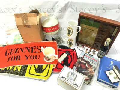 A Collection of vintage pub memorabilia and collectibles including two ceramic Greene King mugs , Taunton Dry Blackthorn cider mug, a collection of beer mats including Guinness, Abbot, Charrington, St Edmunds etc , a Manns novelty "hot air balloon" light, battle of Hastings Guinness tea towels , Abbot ale dice game etc