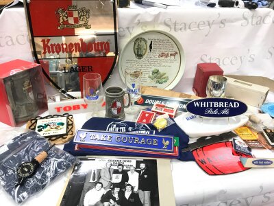 A large box containing vintage pub memorabilia and collectibles including Harp Lager drinking glasses, a large Kronenbourg Lager mirror sign, Green King dish, Harp Lager dish, Guinness cufflinks , card games, Carlsberg dish, large boxed Kronenbourg ceramic tankard, boxed Guinness plastic penguins