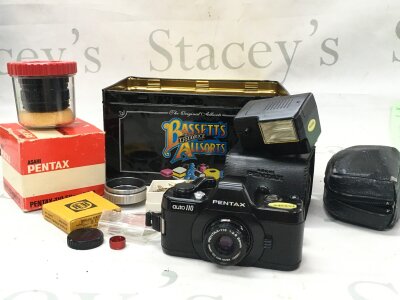 A miniature Pentax auto 110 50mm camera with extra lens and other accessories