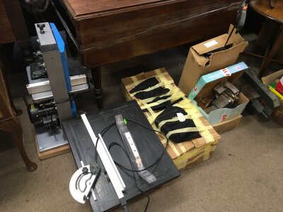 A collection of tools , small workshop lafte, band saws, vices, table top saw, G clamps