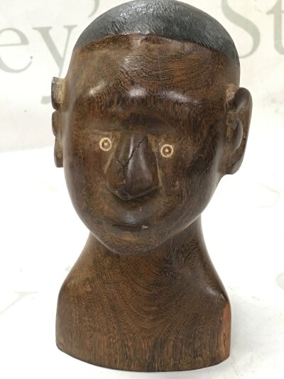 A small African carved bust, base marked Oudtshoorn March 1944 B.K.Nice. 15cm tall