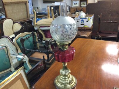 A late 19th century oil lamp with cranberry glass reservoir and brass base .66cm tall