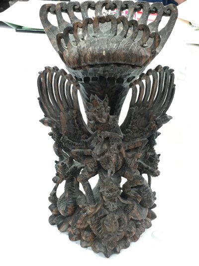 A Balinese intricately carved Hindu deity Vishnu riding his mount Garuda figure, surrounded by dragons. 53cm tall 27cm wide
