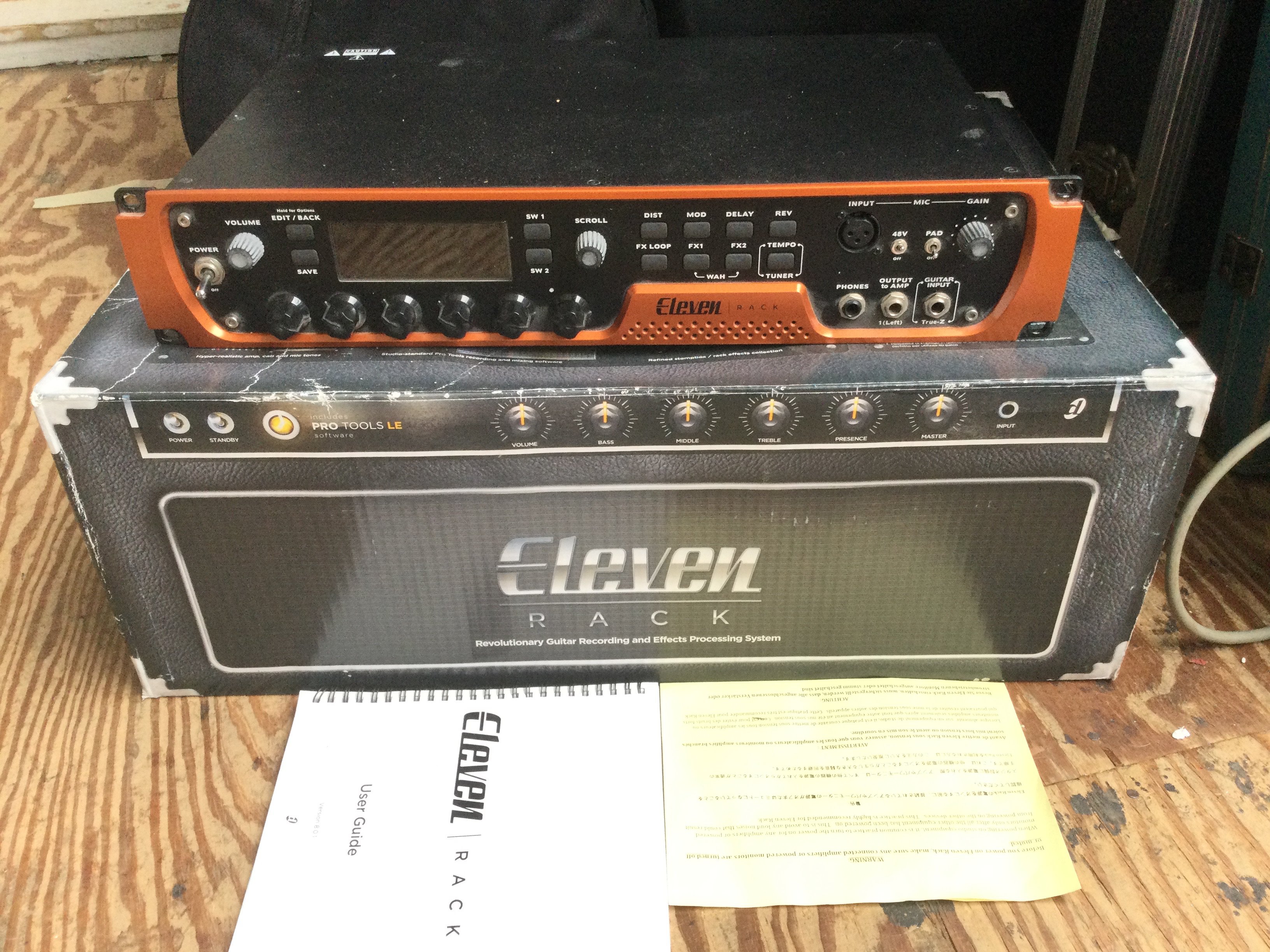A boxed Eleven guitar recording and effects rack system with user guide.