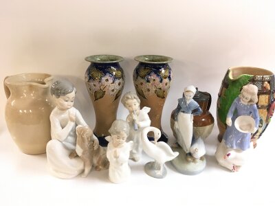 A collection of ceramics including Lladro figures, Doulton figures, Doulton Lambeth jug, pair of Doulton slater patent vases, Beswick jug. Items 13 to 23cm tall