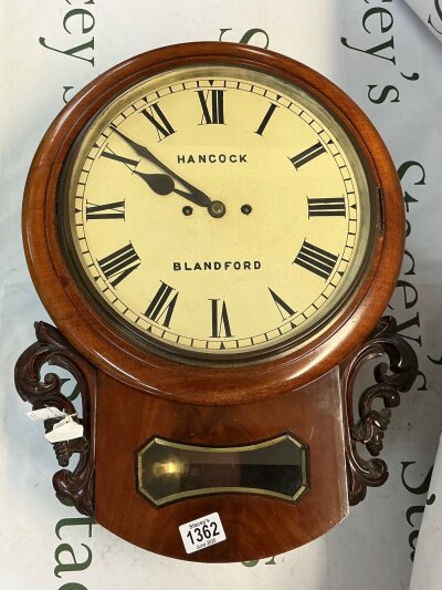 A Victorian double fuse wall clock with a rich walnut casing. It has two winding keyholes indicating it is a spring driven clock that requires winding. The branding is marked on the dial ‘Hancock’ and also at the centre ‘Blandford’.