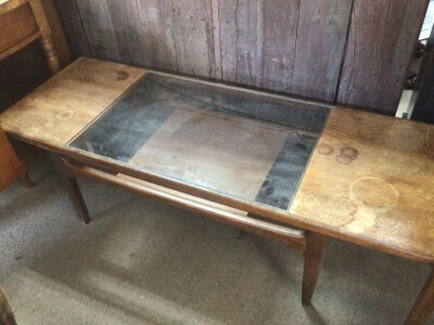 A Mid 20th century design teak table of rectangular shape with a glass inset top above an open shelf. For restoration NO RESERVE.