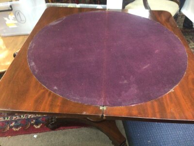 A Victorian Mahogany Card table the twin flap top above a shaped frieze with applied mouldings on a circular column
