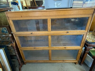 A pair of 1930s oak barrister bookcases with three stackable sections and sliding glass doors.