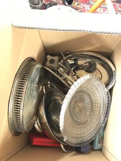 A box containing silver plate dishes, cutlery, a candlestick etc