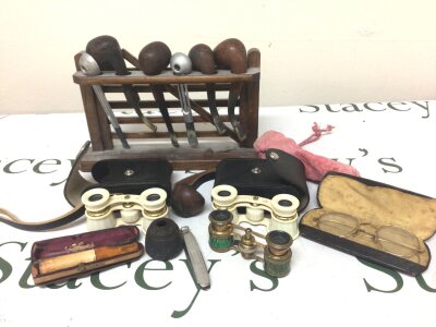 A collection of vintage pipes in a rack three pairs of opera glasses yellow metal rimed vintage spectacles and other ornaments NO RESERVE
