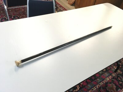An ebonized cane, gold plated top sword stick. Blade 46cm long . Total length 92cm