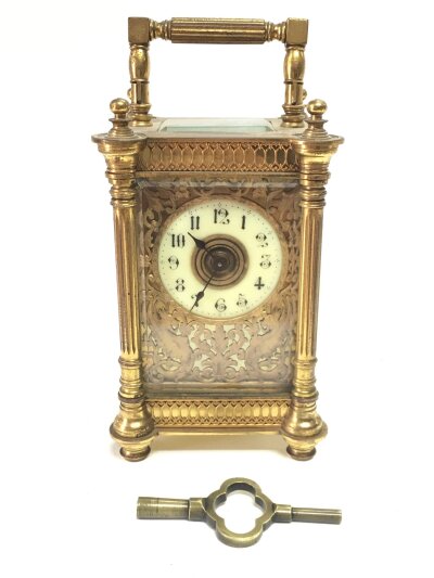 A brass carriage clock, with key seen working. 15cm tall, 9cm wide, 7cm long
