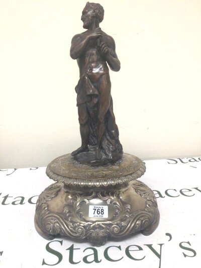 A 19th bronze figure of a Satyr Pan surmounted on a silver plated base with scroll decoration. Height 47cm