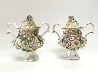 A pair of porcelain pot pourri with floral decoration. 16cm tall