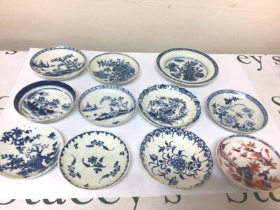 A Collection of eleven 18th Century English porcelain dishes ten blue and white decorated in the Chinese taste and one polychrome Imari influence patterned dish some with hairline cracks most without damage and including a a Worcester butter tub stand C 1770. (11)