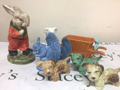 A large Glazed Sylvac model of rabbit design possibly inspired by Peter Rabbit a Koala three dog ornament a wheel barrow and Squirrels. Some damage see image.