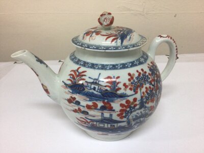An 18th century Royal Worcester Canon ball tea pot decorated with Chinese influences with red and underglaze blue with applied gilt the lid with raised flower finial. Mark to the base in underglaze blue Restoration to the edge of the lid see image