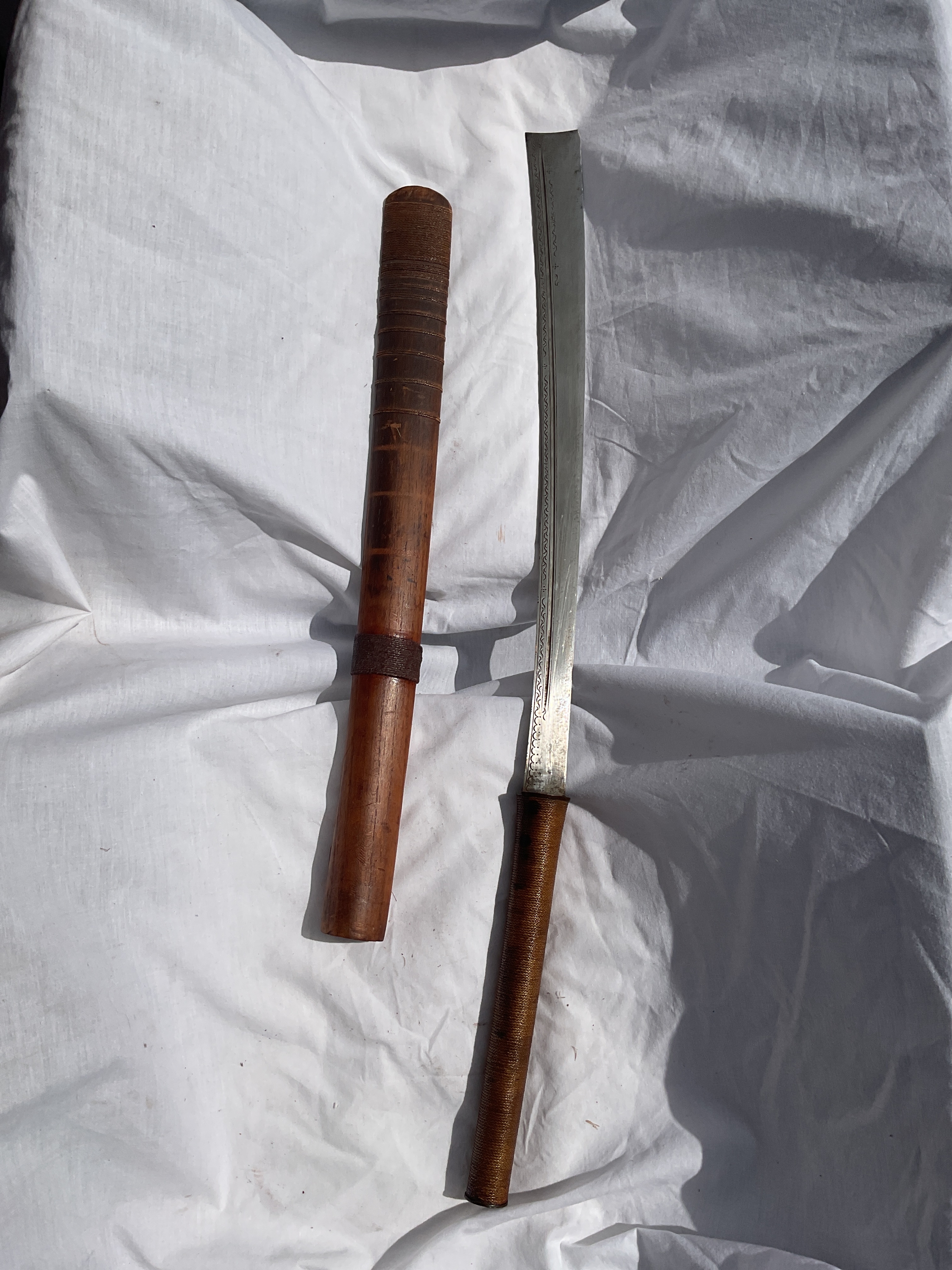 Indonesian flat ended sword very sharp, in original string bound sheath 